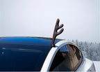 Tesla Car with a deer antler decoration against a snowy background