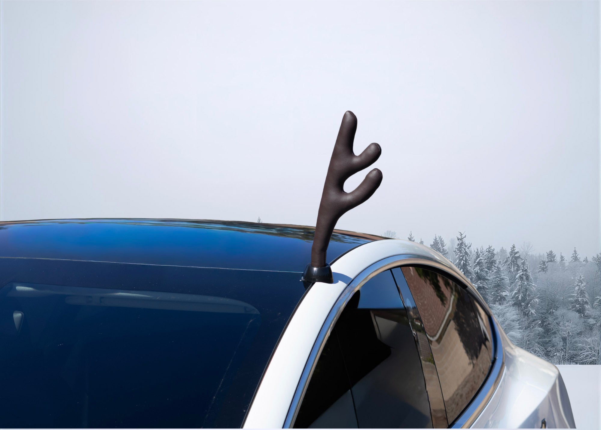 Tesla Car with a deer antler decoration against a snowy background