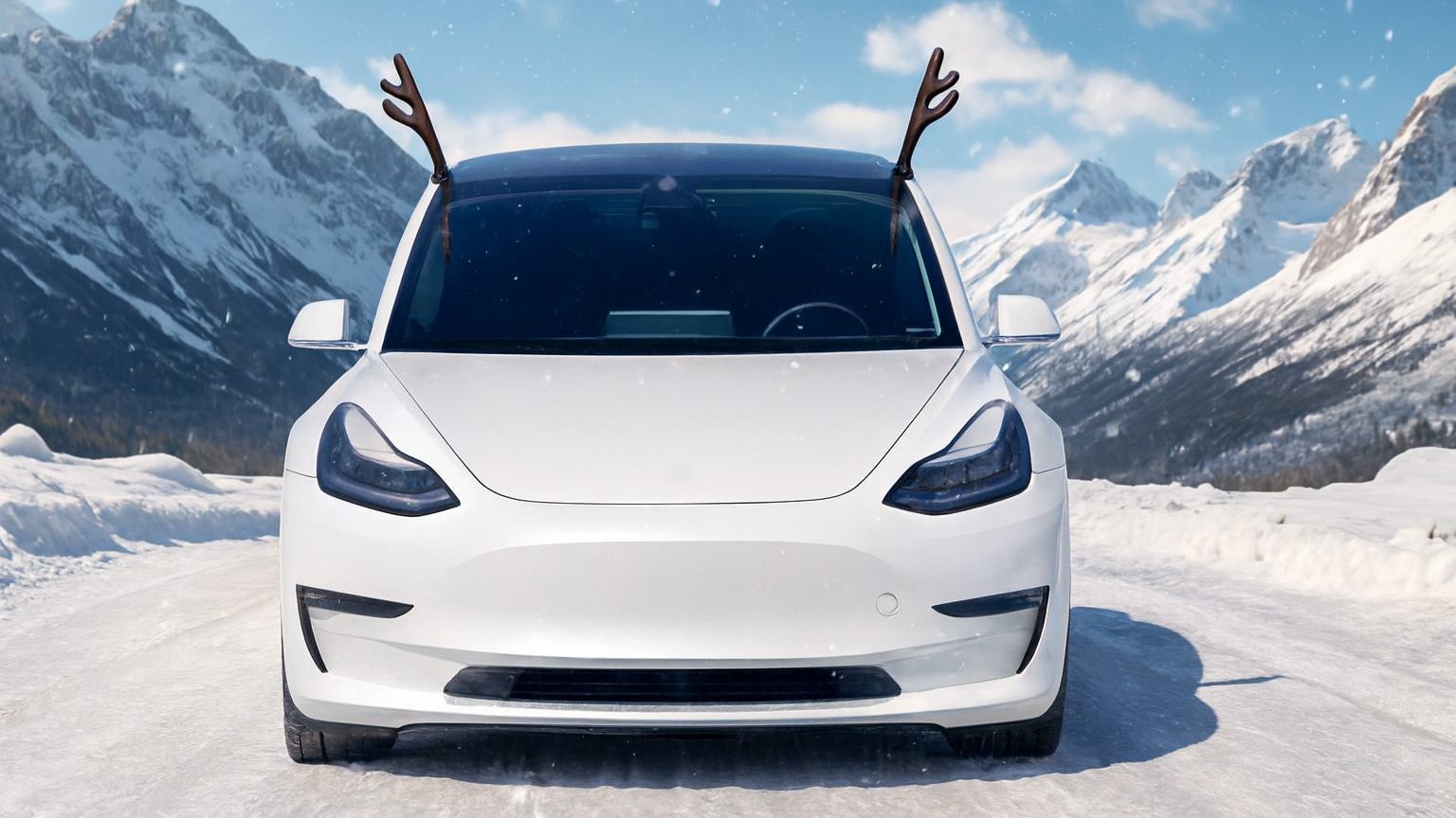 White electric car in a snowy landscape with mountains in the background